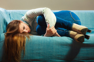Loneliness negative emotion concept. Young sad stressed woman lying on couch at home